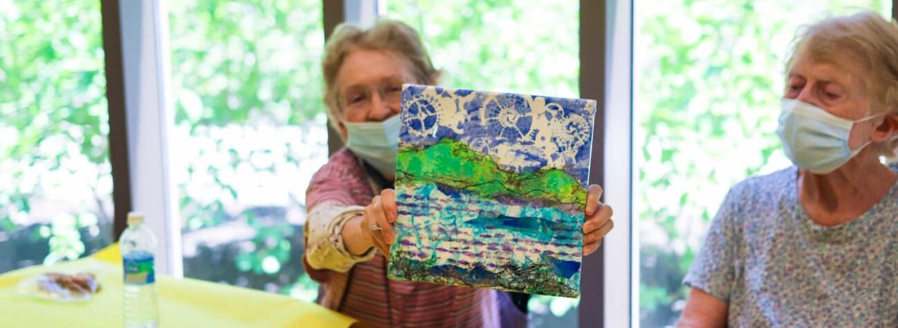 a patient showcasing her painting
