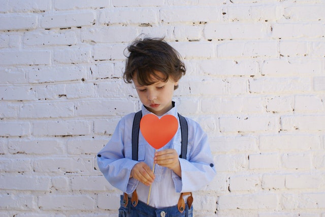 Young boy holding paper heart