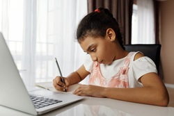 school-aged girl, mixed race, doing homework