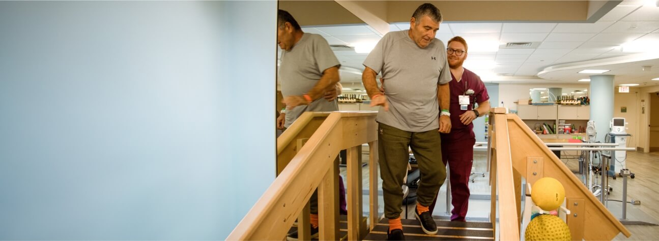 man being assisted by a physical therapist